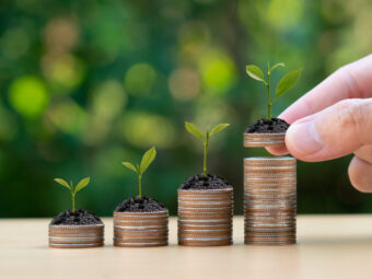 Saving money concept. Hand putting Coins with small plant. Busin